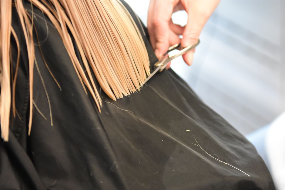 Coiffeuse concentrée pendant une coupe de cheveux